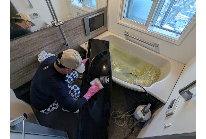 浴室で取り外した部品を清掃する作業風景（参考写真）